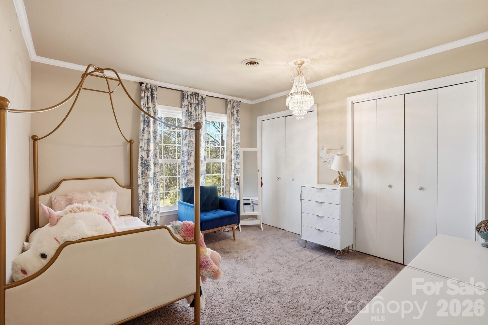 6046 Windjammer Drive Tega Cay, SC 29708 - Photo 34 of 46 a bedroom with a bed and a chandelier