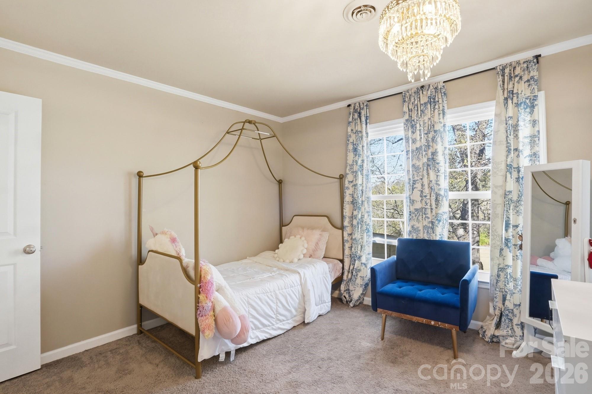 6046 Windjammer Drive Tega Cay, SC 29708 - Photo 35 of 46 a bedroom with a bed couch chandelier and a window