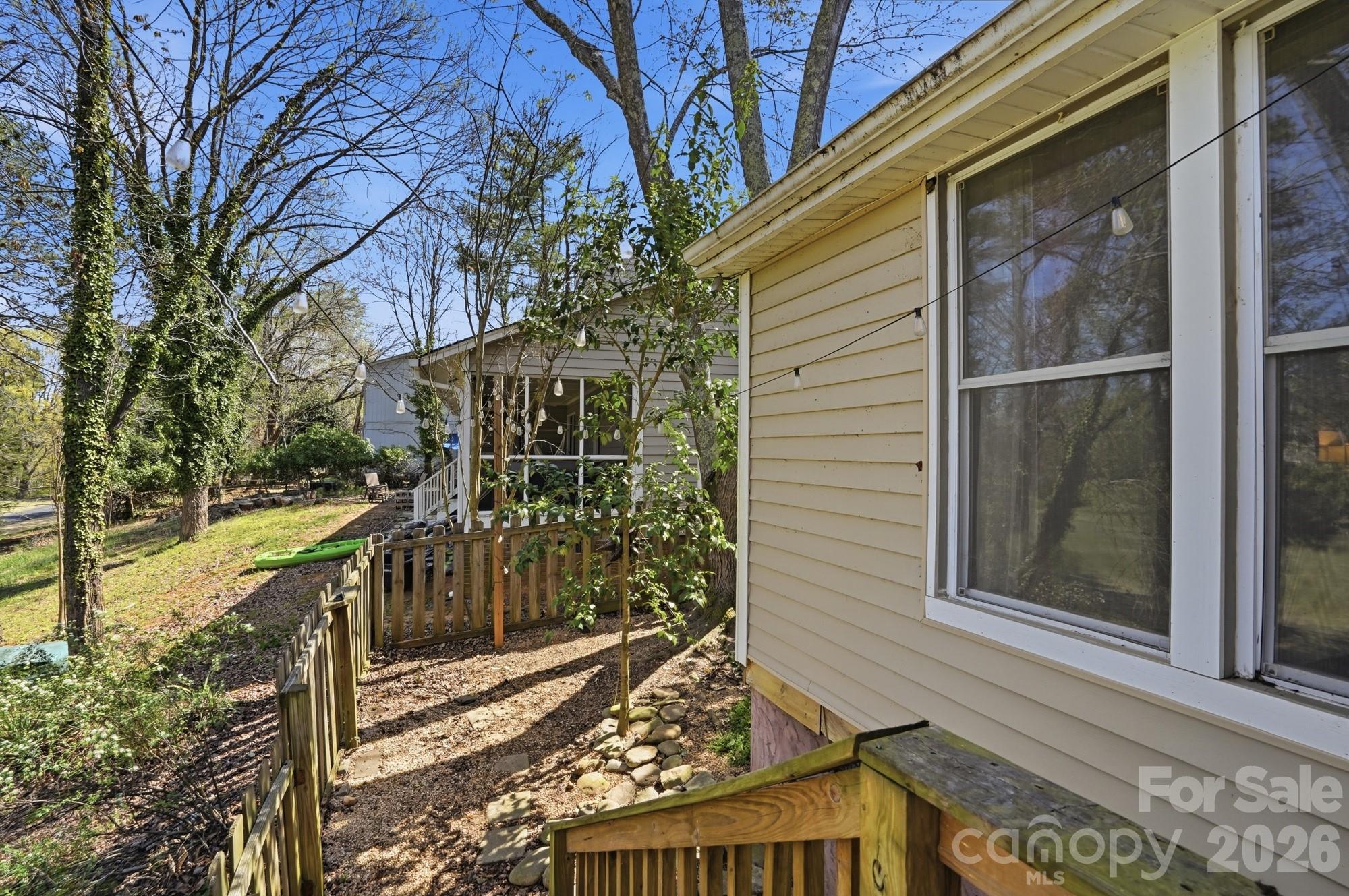 6046 Windjammer Drive Tega Cay, SC 29708 - Photo 42 of 46 a view of a brick house with a large tree