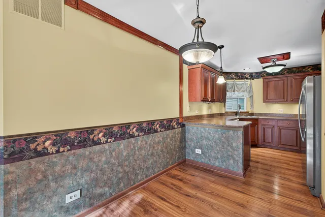 a kitchen with granite countertop a stove a sink and a wooden floor