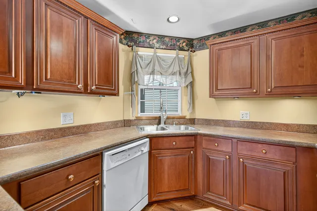 a kitchen with granite countertop a sink a stove and cabinets