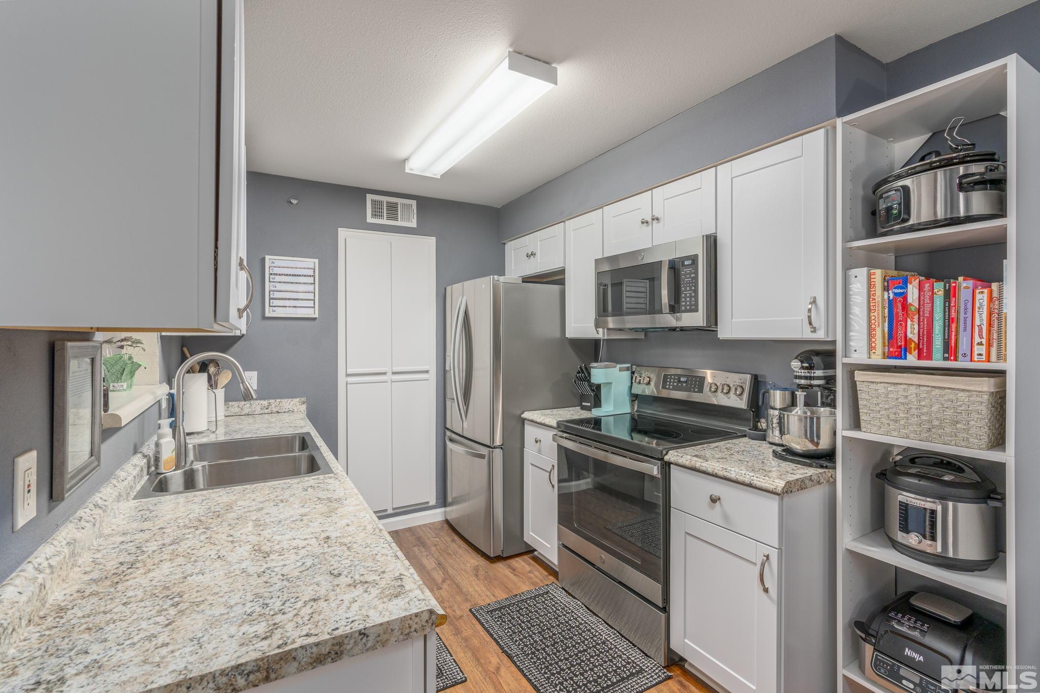 6850 Sharlands Avenue, Unit S2106 Reno, NV 89523 - Photo 16 of 36 a kitchen with granite countertop a refrigerator and a stove top oven