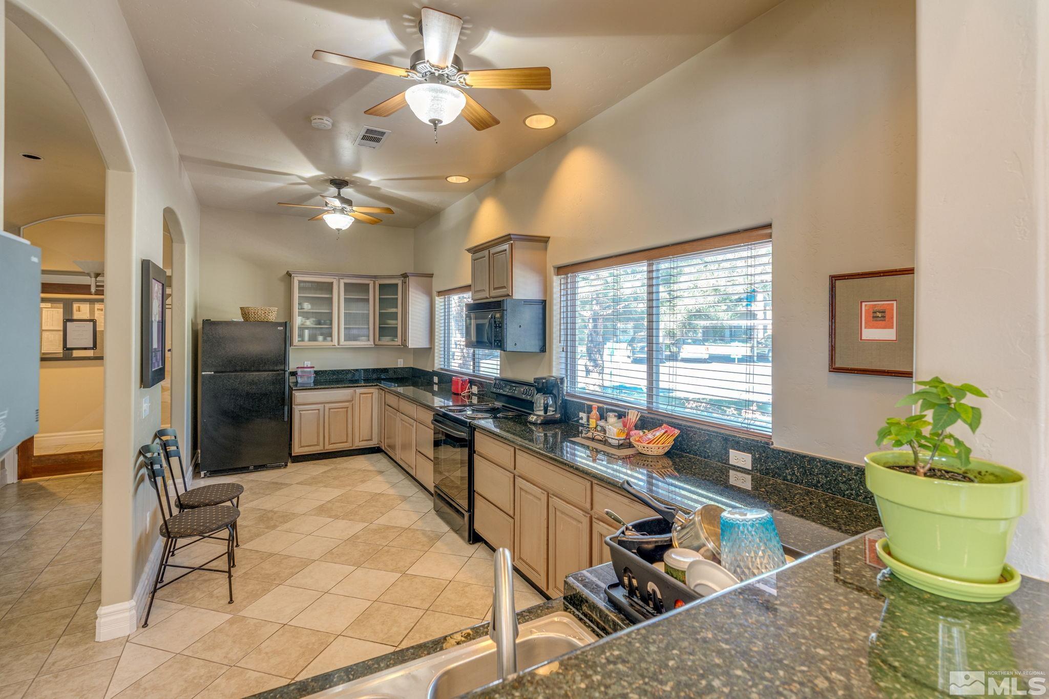 6850 Sharlands Avenue, Unit S2106 Reno, NV 89523 - Photo 31 of 36 a kitchen with a stove a refrigerator and couches