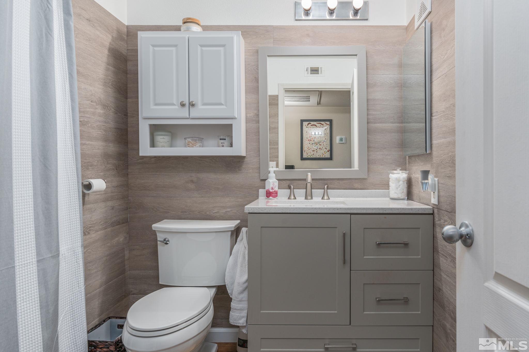 6850 Sharlands Avenue, Unit S2106 Reno, NV 89523 - Photo 9 of 36 a bathroom with a toilet a sink a vanity and mirror