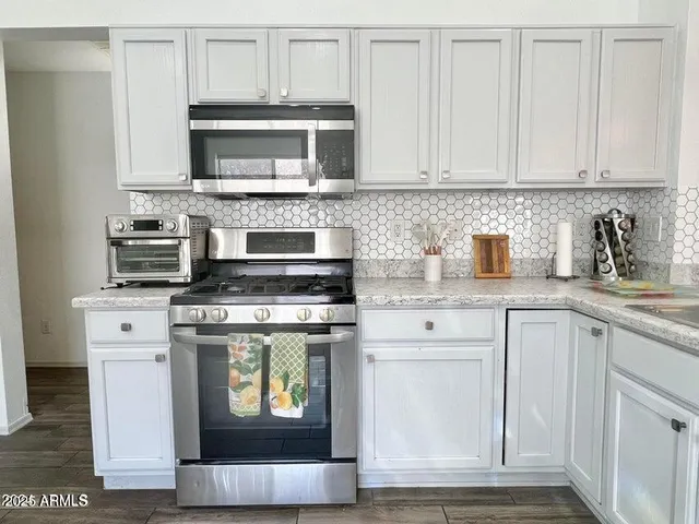 a kitchen with stainless steel appliances granite countertop a stove a microwave and cabinets