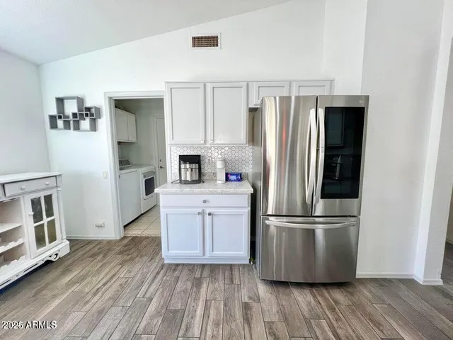 a kitchen with stainless steel appliances a refrigerator and wooden floor