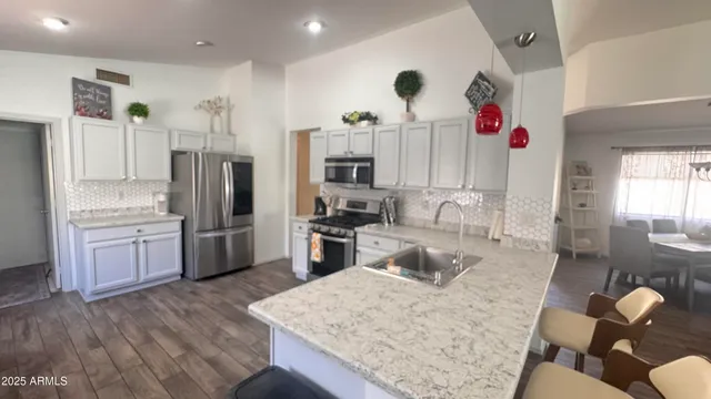 a kitchen with stainless steel appliances granite countertop a refrigerator sink and cabinets