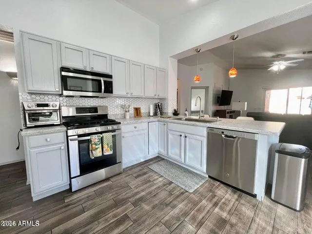 a kitchen with a sink white cabinets and stainless steel appliances