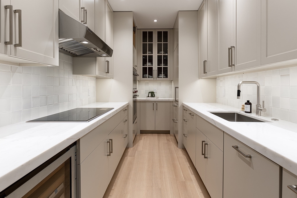 21 Chestnut Street Weston, MA 02493 - Photo 13 of 34 a kitchen with a sink dishwasher and white cabinets with wooden floor