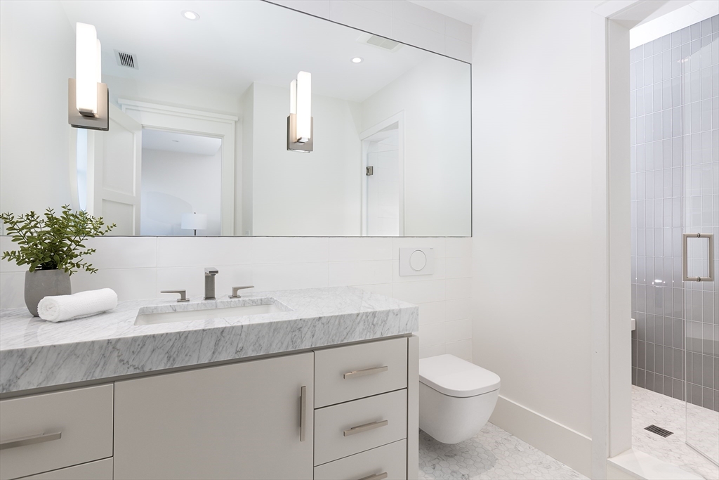 21 Chestnut Street Weston, MA 02493 - Photo 27 of 34 a bathroom with a granite countertop sink a toilet and a mirror