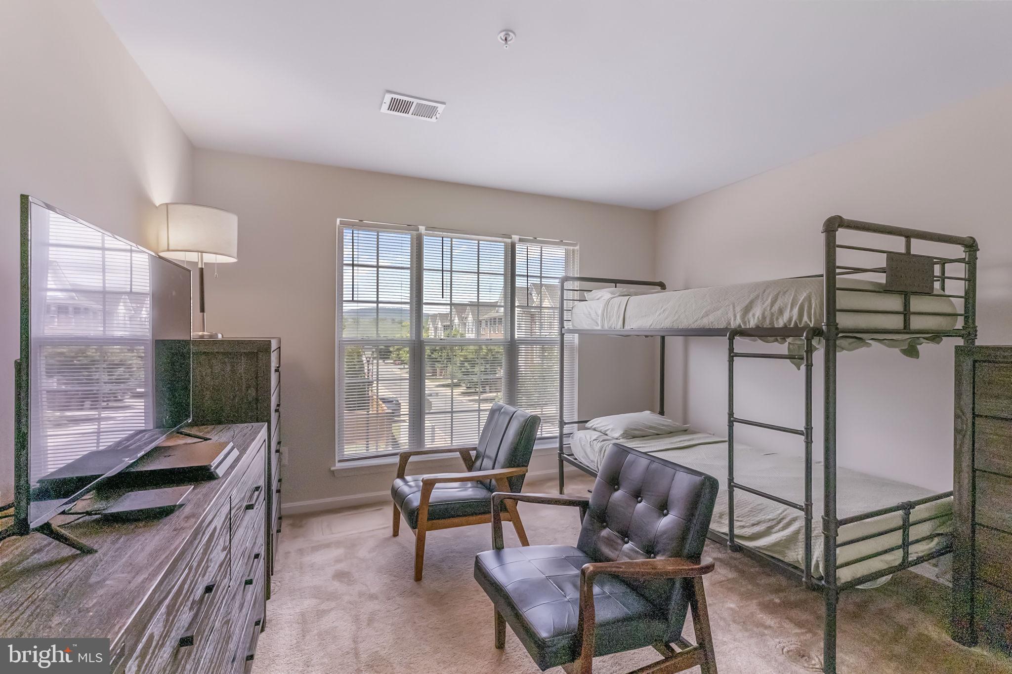 127 Mountain Creek Circle Frederick, MD 21702 - Photo 22 of 26 a living room with furniture a flat screen tv and a floor to ceiling window