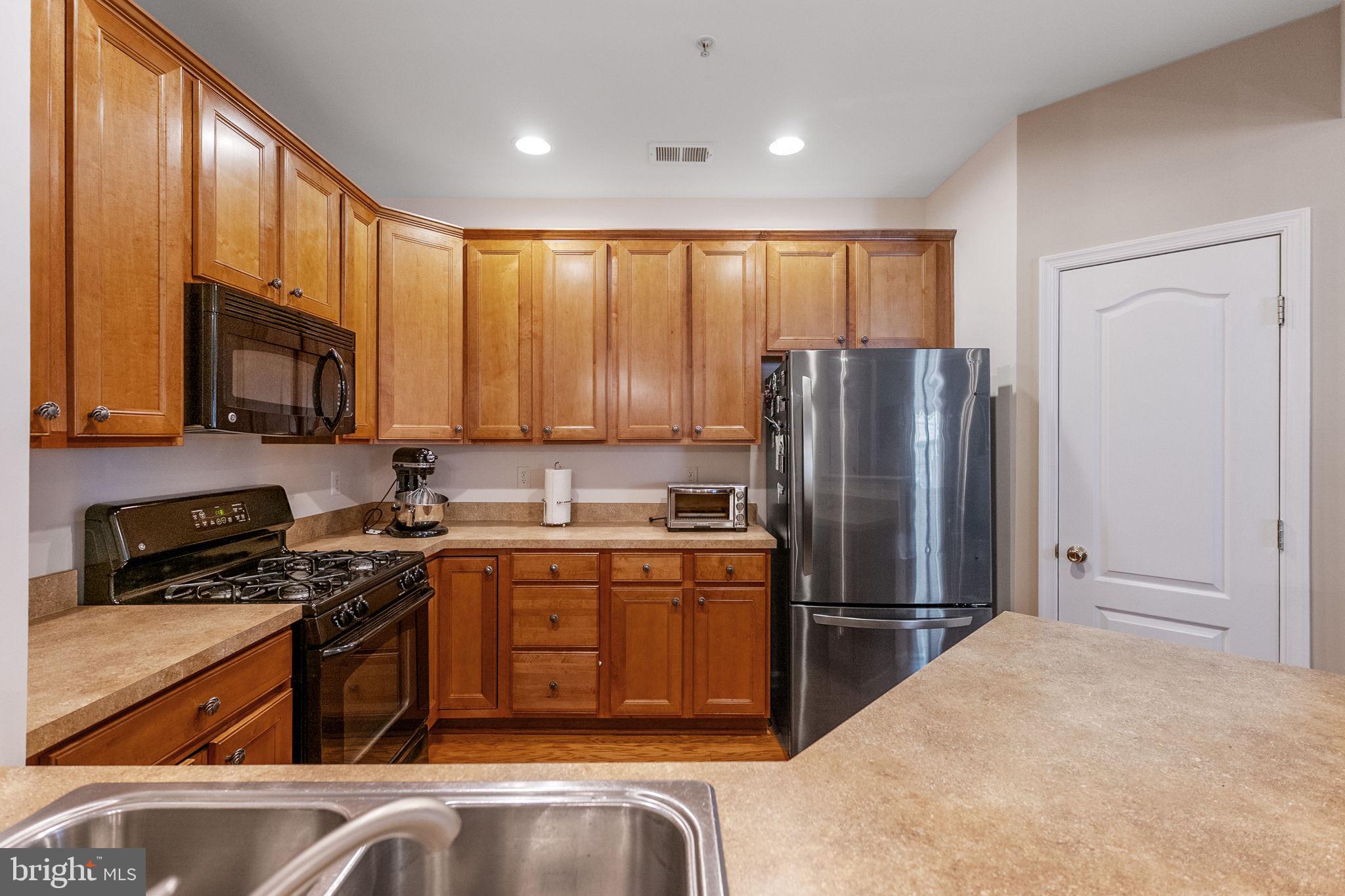 127 Mountain Creek Circle Frederick, MD 21702 - Photo 5 of 26 a kitchen with stainless steel appliances granite countertop a stove top oven a refrigerator a sink and dishwasher
