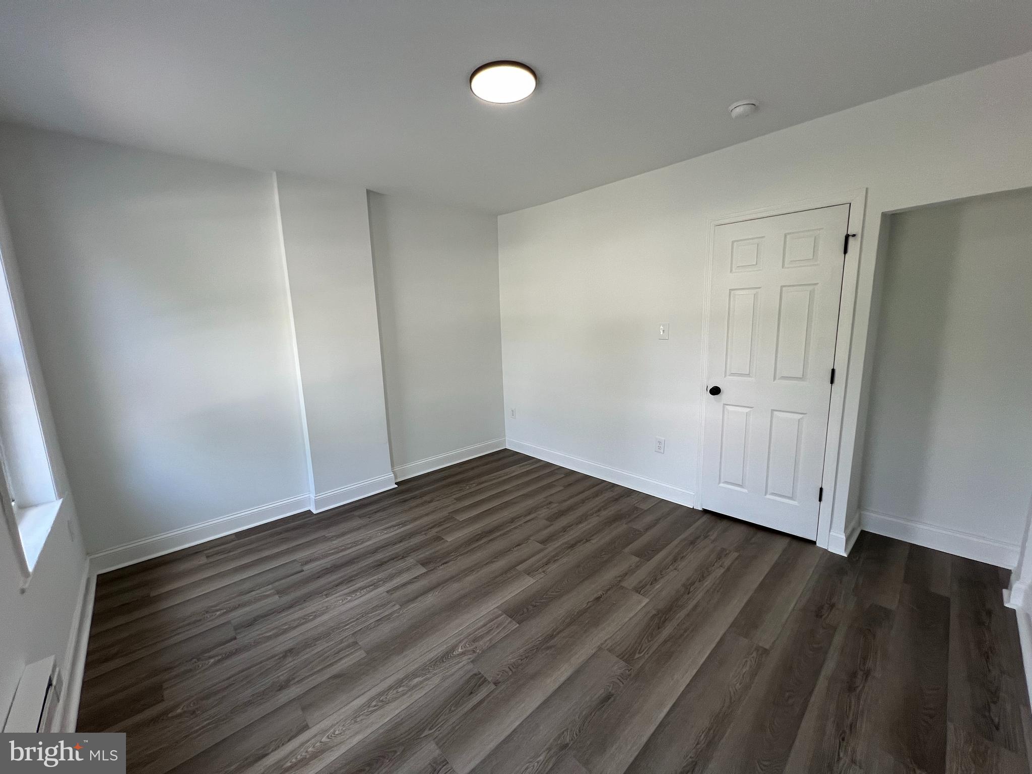 921 West 3rd Street Chester, PA 19013 - Photo 16 of 18 an empty room with wooden floor and windows