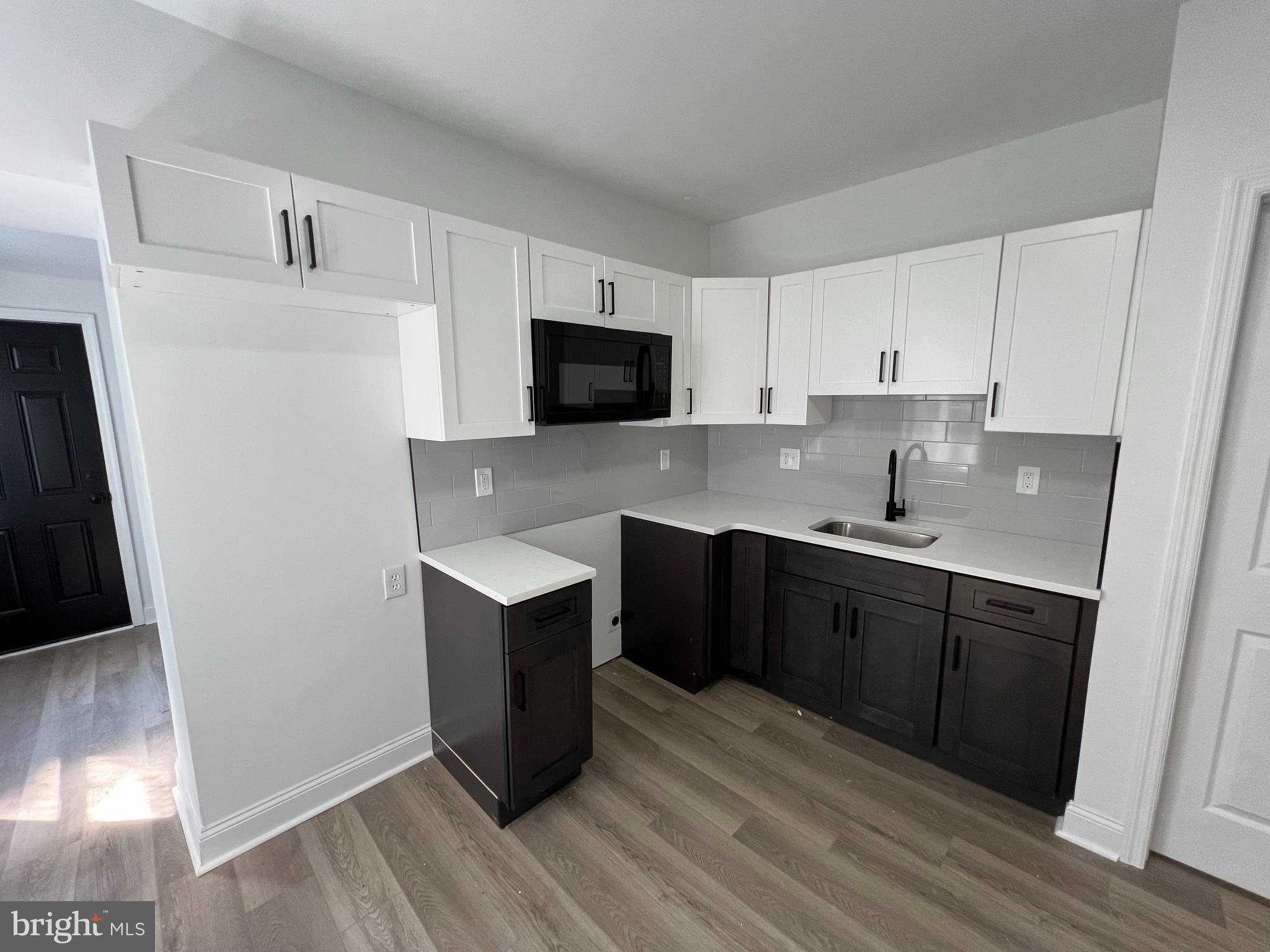 921 West 3rd Street Chester, PA 19013 - Photo 2 of 18 a kitchen with a sink a microwave and cabinets