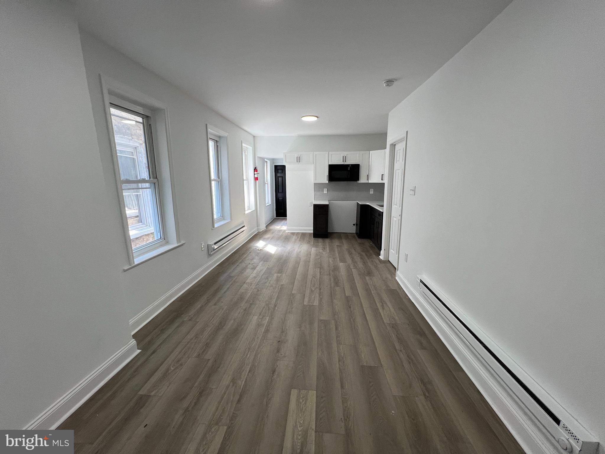 921 West 3rd Street Chester, PA 19013 - Photo 4 of 18 a view of a livingroom with wooden floor staircase and a kitchen