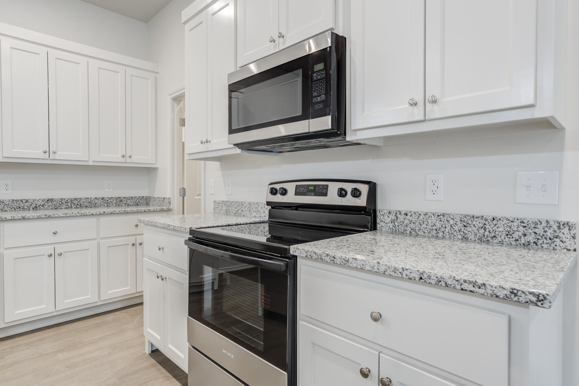 7007 40th Street Lubbock, TX 79407 - Photo 11 of 30 a kitchen with granite countertop white cabinets and a stove a oven with white countertops
