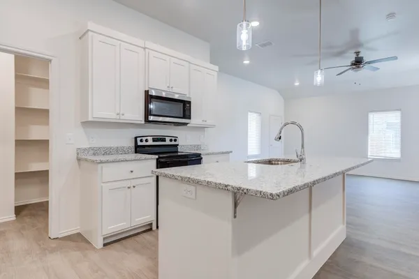 a kitchen with stainless steel appliances granite countertop a sink a stove and a microwave