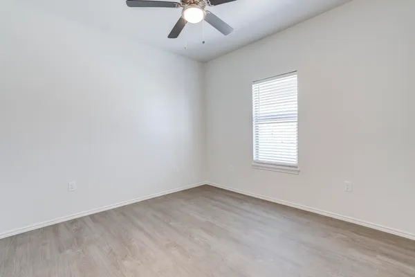 an empty room with wooden floor and window