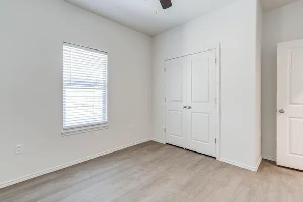 a view of an empty room and chandelier fan