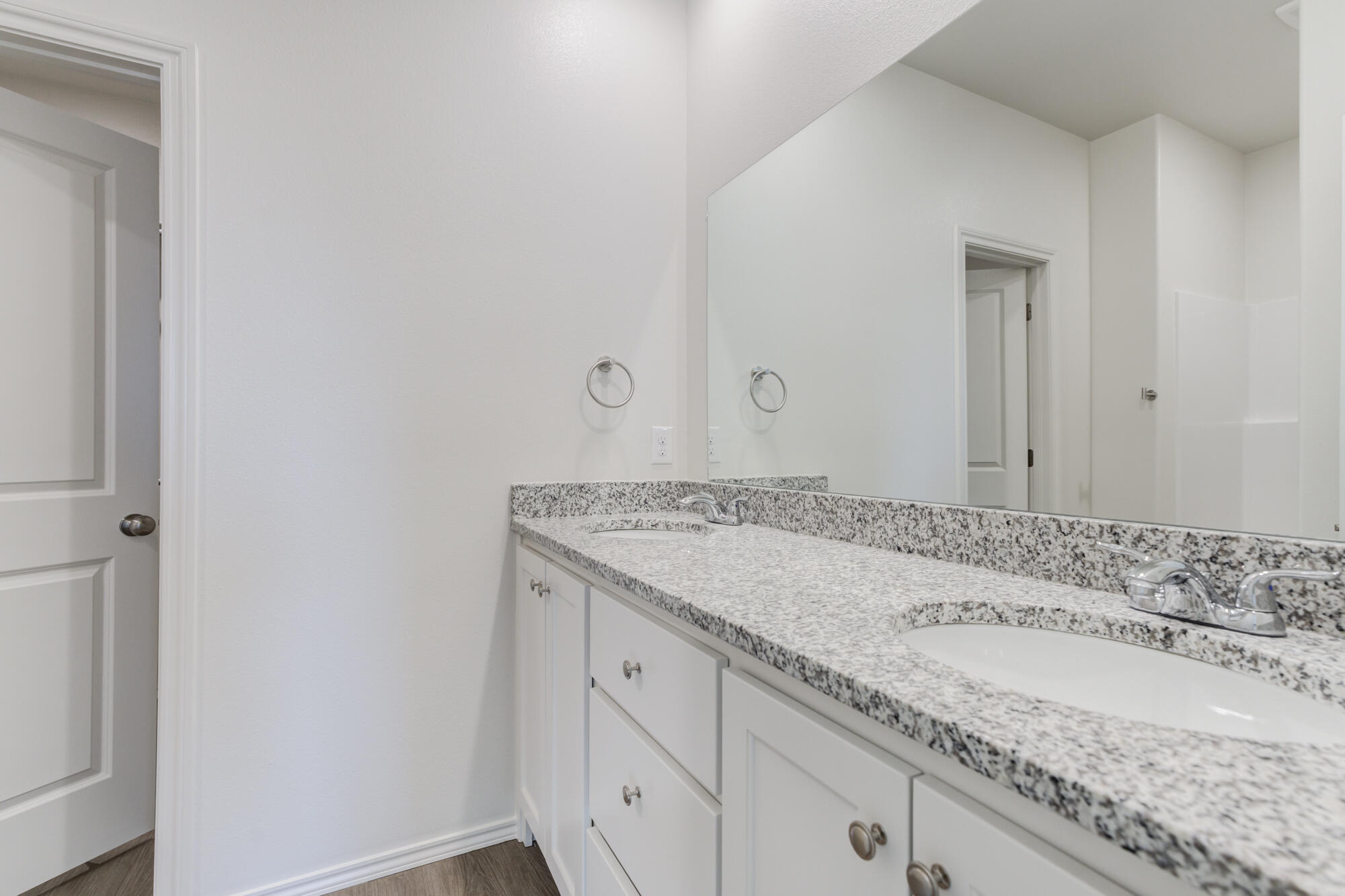 7007 40th Street Lubbock, TX 79407 - Photo 23 of 30 a bathroom with a granite countertop sink and white cabinets