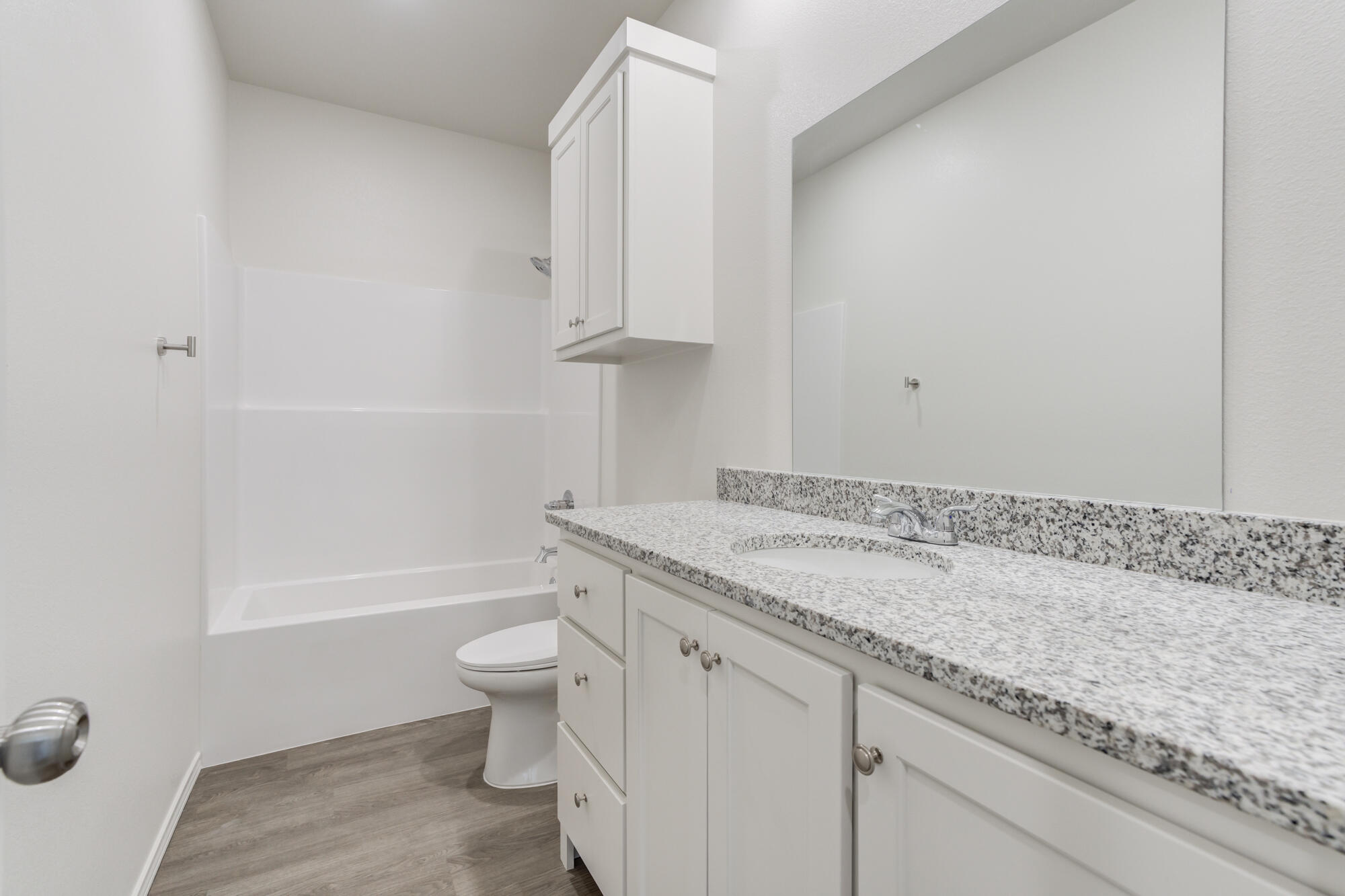 7007 40th Street Lubbock, TX 79407 - Photo 29 of 30 a bathroom with a granite countertop sink a toilet and bathtub