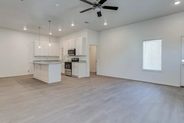 a view of kitchen with stainless steel appliances refrigerator stove microwave and cabinets