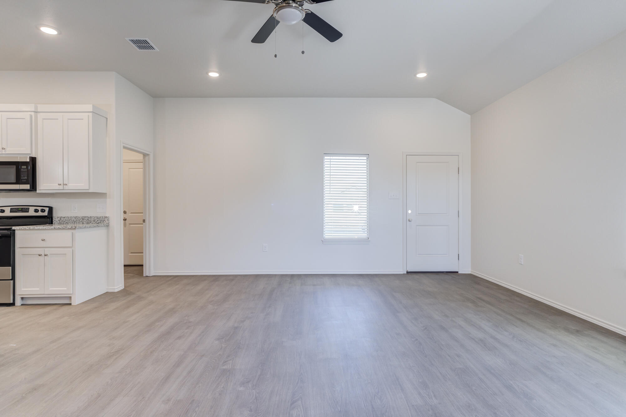 7007 40th Street Lubbock, TX 79407 - Photo 5 of 30 wooden floor in an empty room with a window