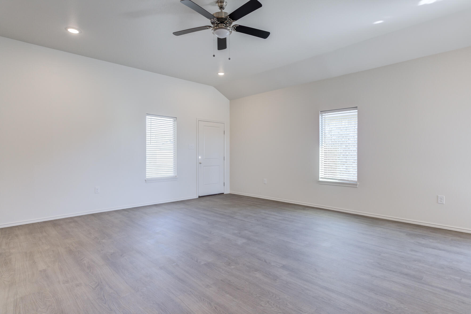 7007 40th Street Lubbock, TX 79407 - Photo 6 of 30 an empty room with wooden floor fan and windows