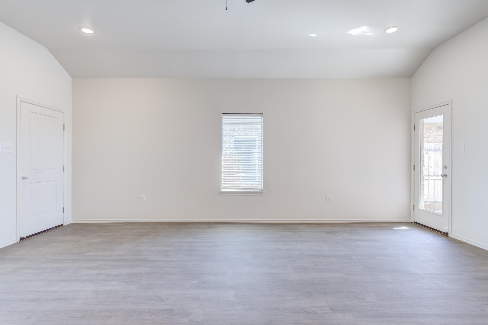 7007 40th Street Lubbock, TX 79407 - Photo 7 of 30 an empty room with wooden floor and windows