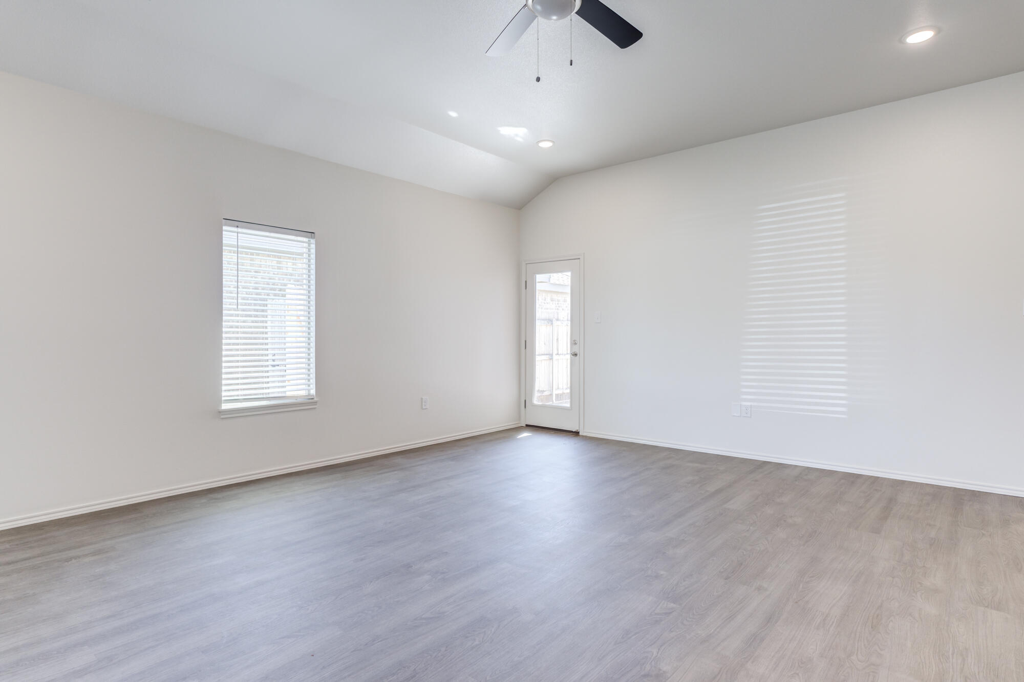 7007 40th Street Lubbock, TX 79407 - Photo 8 of 30 an empty room with wooden floor and windows