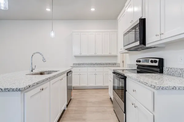 a kitchen with stainless steel appliances granite countertop a sink stove and cabinets
