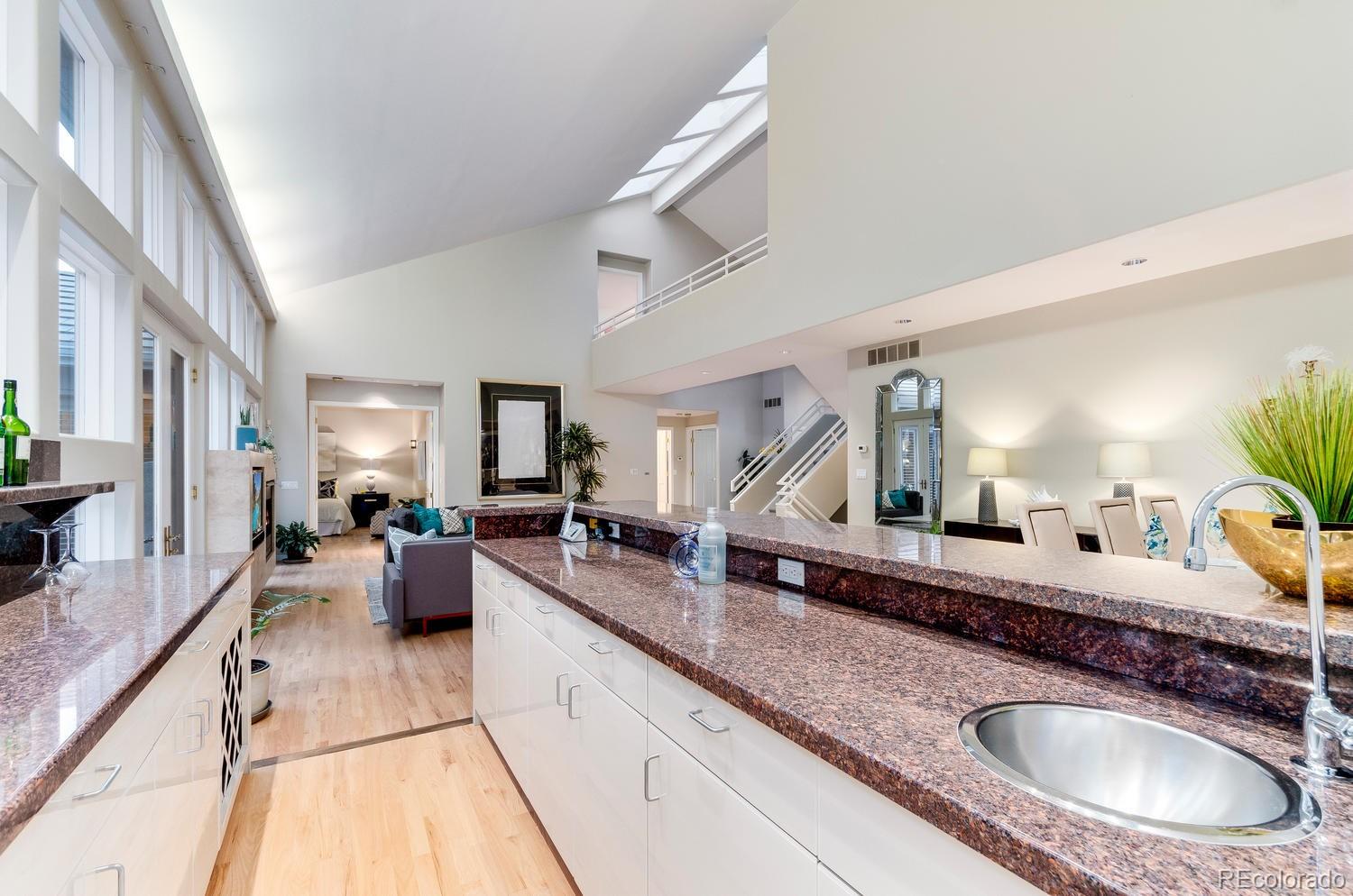 27 Hyde Park Circle Denver, CO 80209 - Photo 11 of 40 a large kitchen with granite countertop a sink a counter top space and living room view