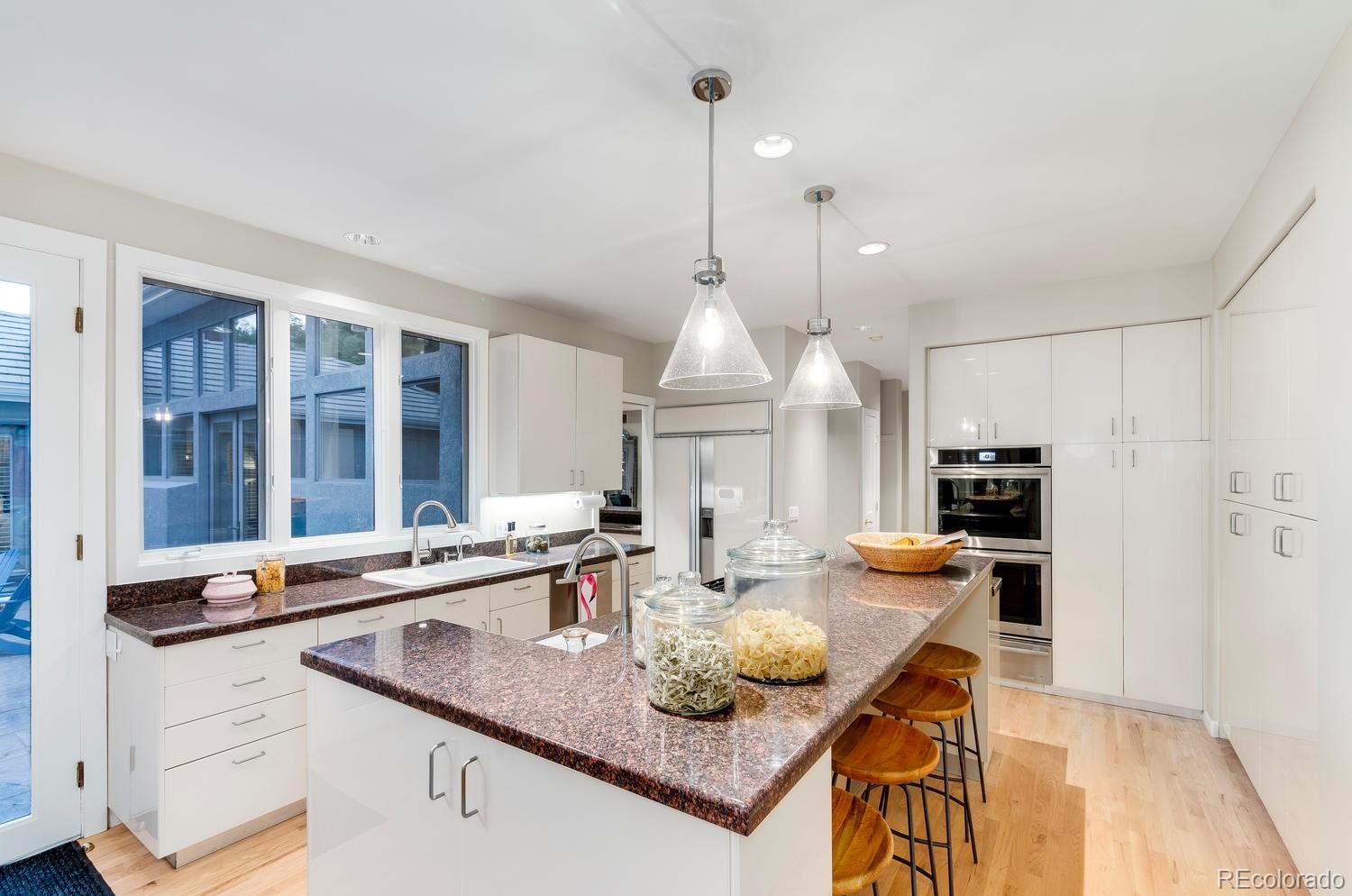 27 Hyde Park Circle Denver, CO 80209 - Photo 14 of 40 a kitchen with stainless steel appliances granite countertop a sink a stove and a wooden floors