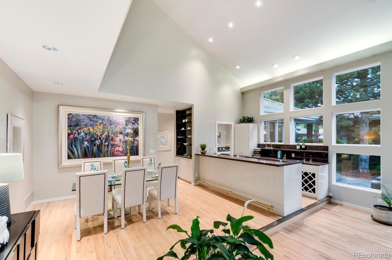27 Hyde Park Circle Denver, CO 80209 - Photo 7 of 40 a kitchen with stainless steel appliances granite countertop a stove top oven a sink a dining table and chairs with wooden floor
