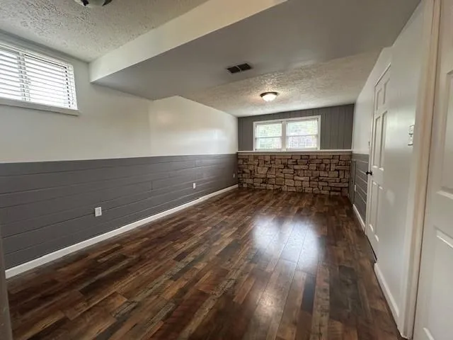 a view of empty room with wooden floor