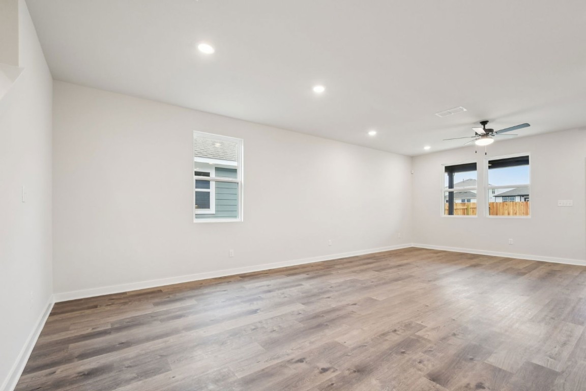 13417 Derby Ride Drive Buda, TX 78610 - Photo 12 of 38 an empty room with wooden floor and windows
