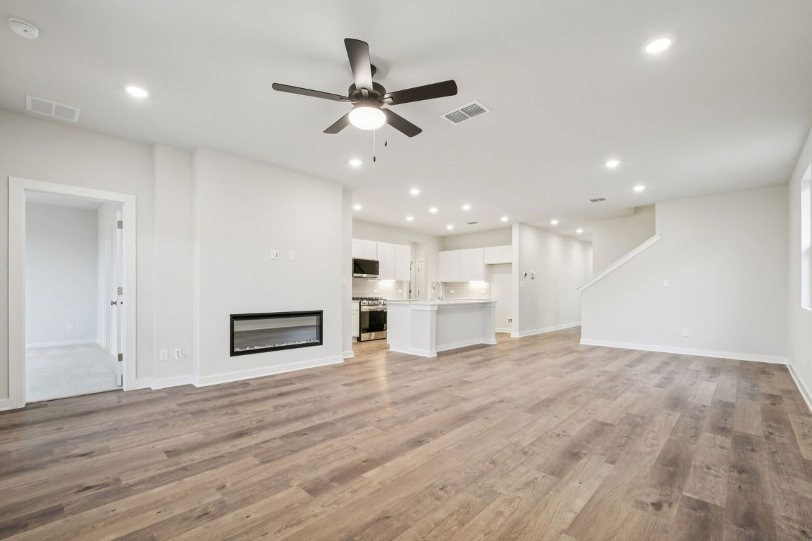 13417 Derby Ride Drive Buda, TX 78610 - Photo 13 of 38 a view of a livingroom with a ceiling fan wooden floor and window