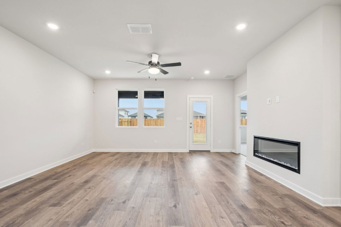 13417 Derby Ride Drive Buda, TX 78610 - Photo 14 of 38 an empty room with wooden floor and windows