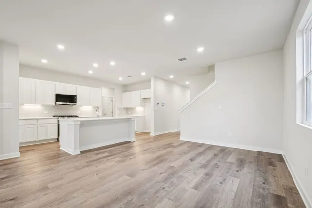 a view of kitchen with cabinets microwave and stove