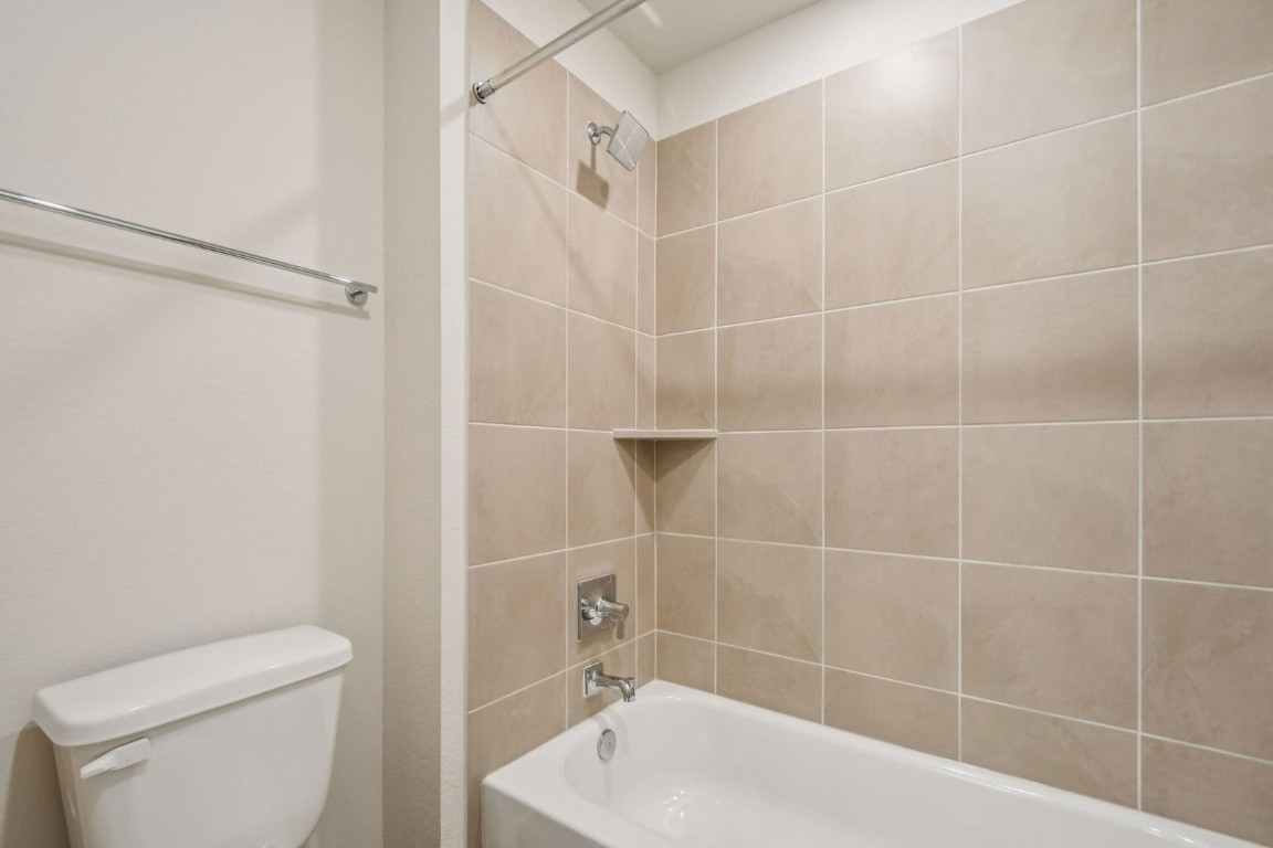 13417 Derby Ride Drive Buda, TX 78610 - Photo 25 of 38 a bathroom with a toilet and a bathtub