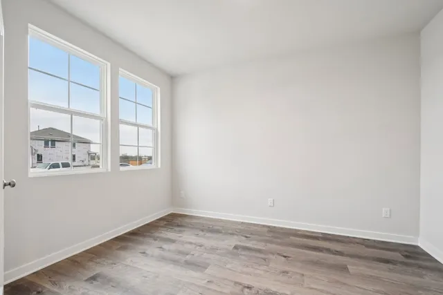 wooden floor in an empty room with a window