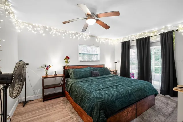 a bedroom with a bed dresser and a large window