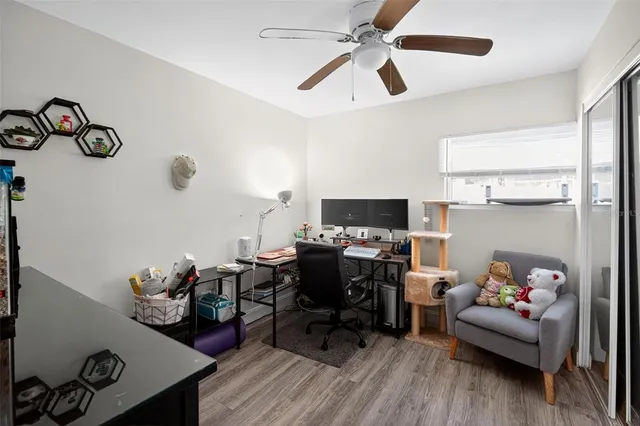 a view of a workspace with furniture and a ceiling fan