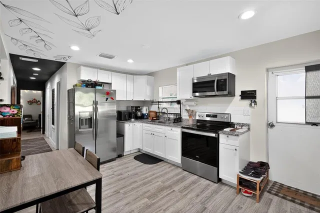 a kitchen with stainless steel appliances granite countertop a refrigerator stove microwave and sink