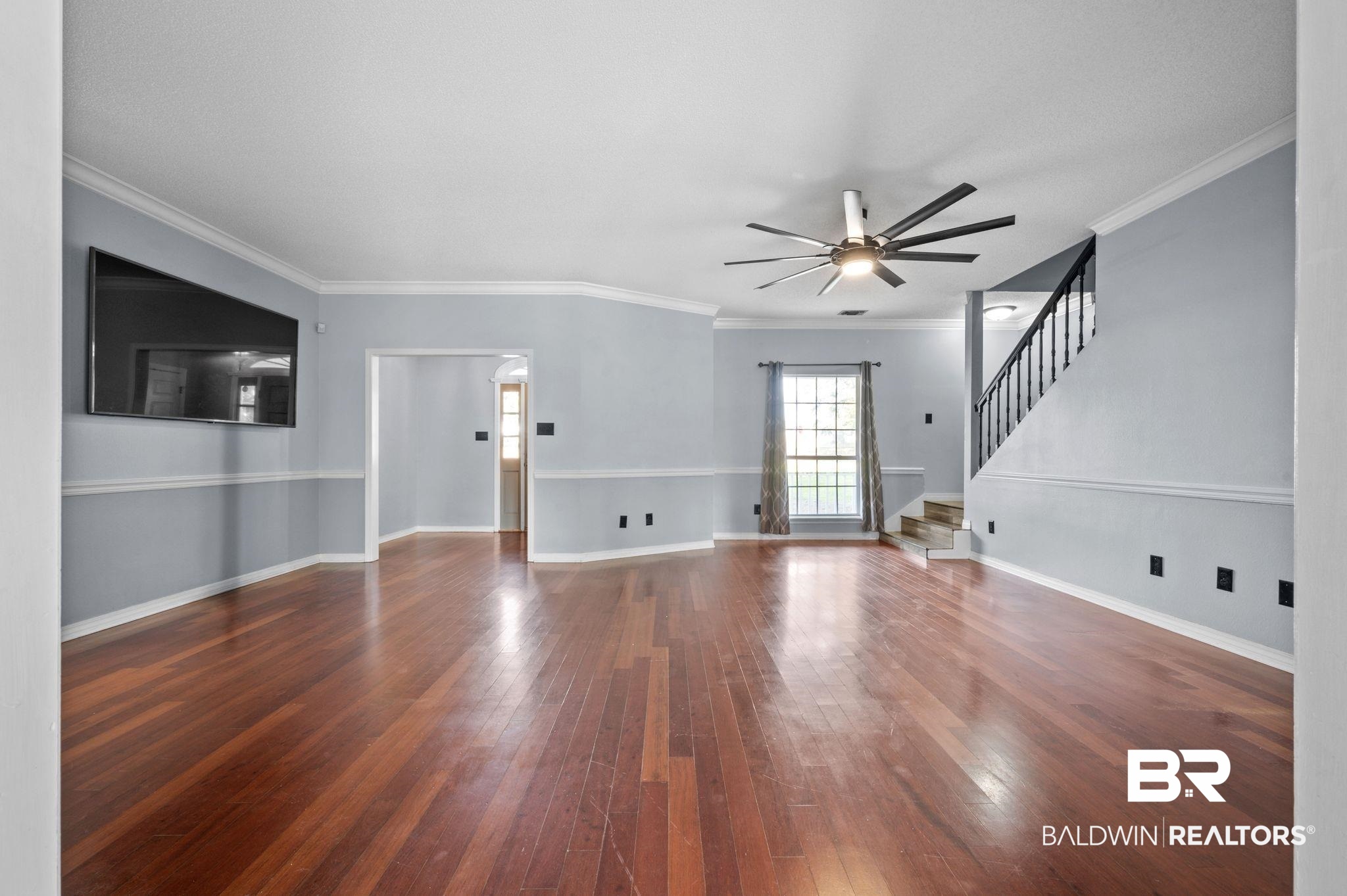100 Orleans Way Daphne, AL 36526 - Photo 8 of 31 Unfurnished living room with crown molding, dark hardwood / wood-style flooring, and ceiling fan