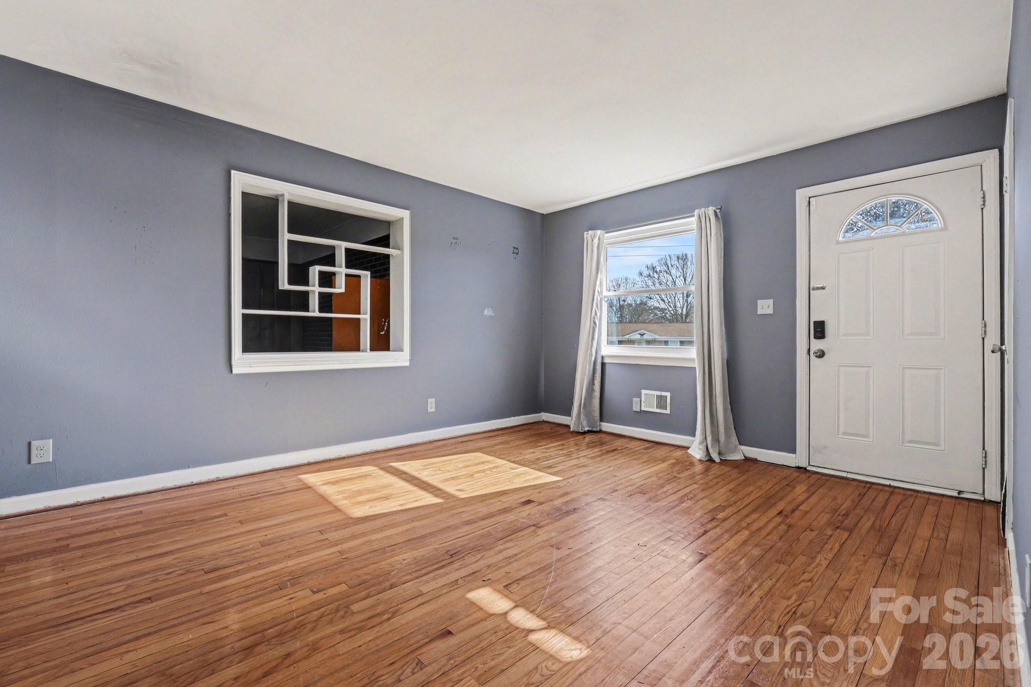 110 Abell Street Chester, SC 29706 - Photo 6 of 29 a view of an empty room with wooden floor and a window