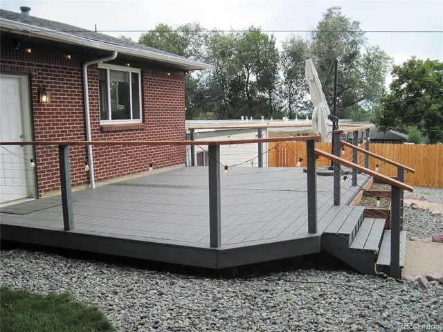 a view of a balcony with wooden floor and fence