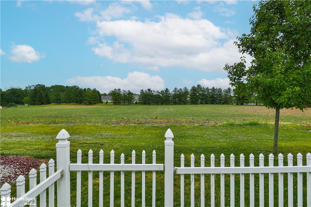 507 Howertown Road Northampton, PA 18067 - Photo 45 of 46 A classic white picket fence encloses a vast, verdant field, offering serene countryside vistas.
