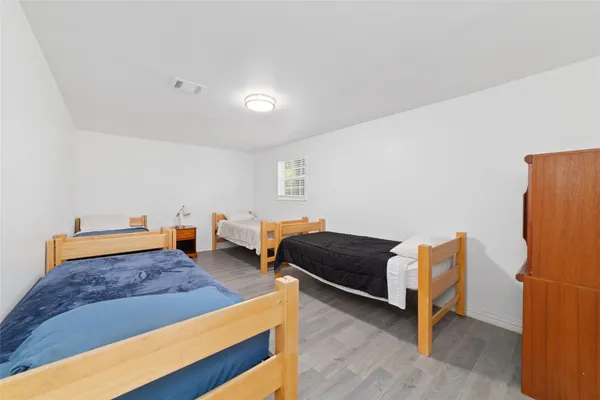 a bedroom with furniture and a wooden floor