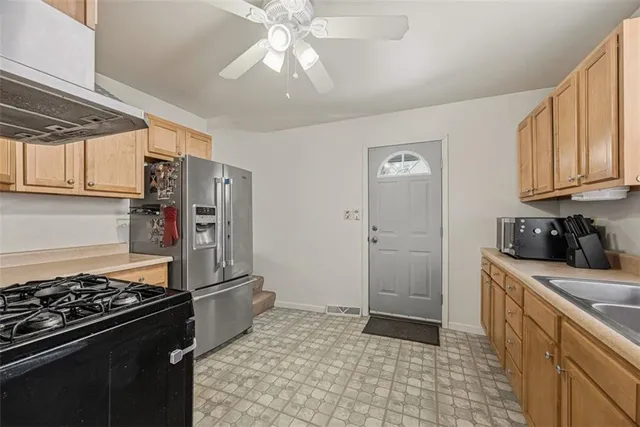a kitchen with stainless steel appliances granite countertop a refrigerator and a stove top oven